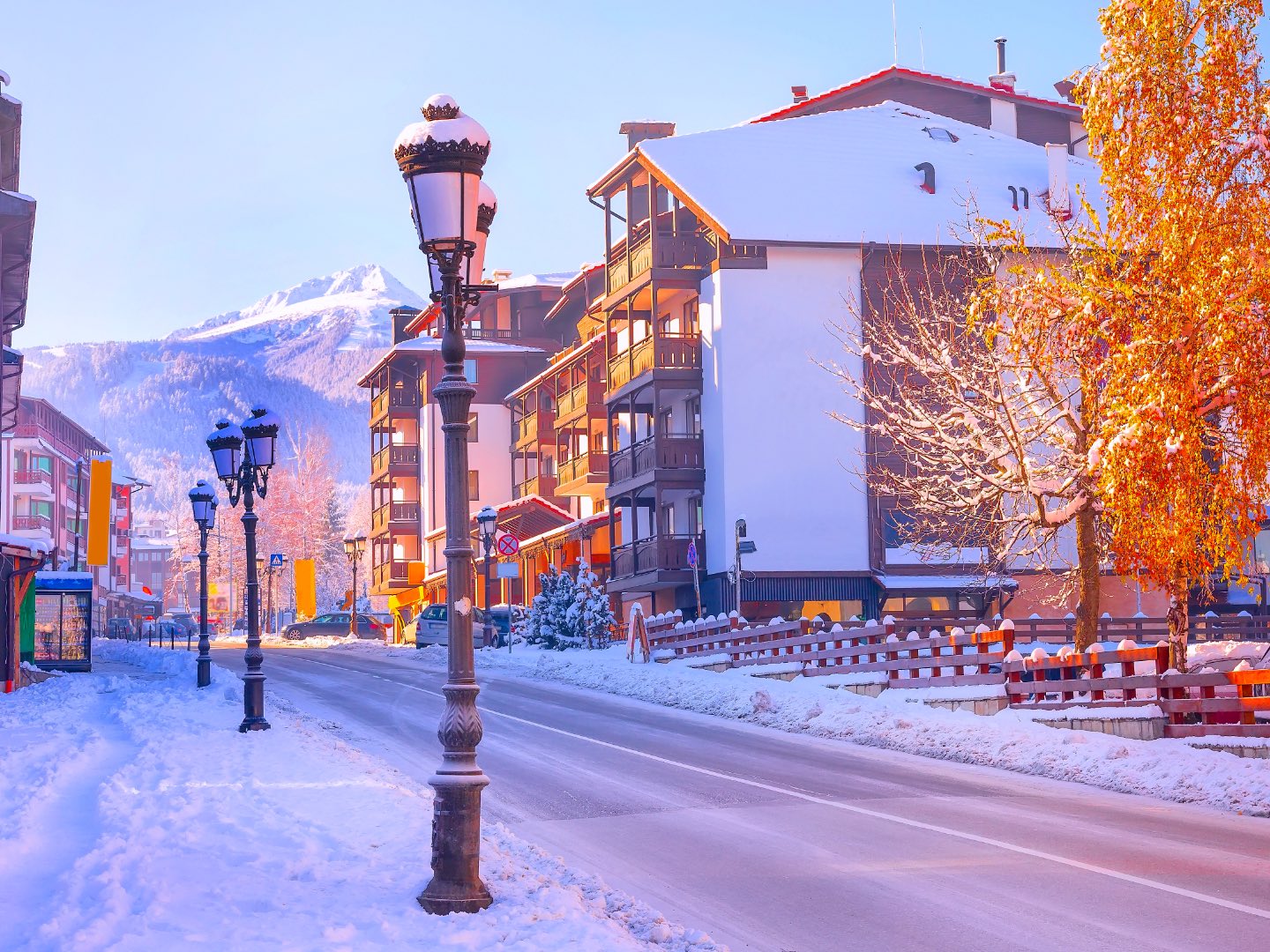 Χειμερινή άποψη του Bansko στη νοτιοδυτική Βουλγαρία, με χιονισμένους δρόμους, ορεινή αρχιτεκτονική και τις κορυφές των Pirin στο βάθος. Από εδώ ξεκινά το Pirin Alpine Crossing, με δύο ημέρες για σκι, περιήγηση και χαλάρωση πριν από την ορειβατική διάσχιση προς το Sandanski. Χιονισμένος δρόμος στο Bansko με τις κορυφές των Pirin στο βάθος