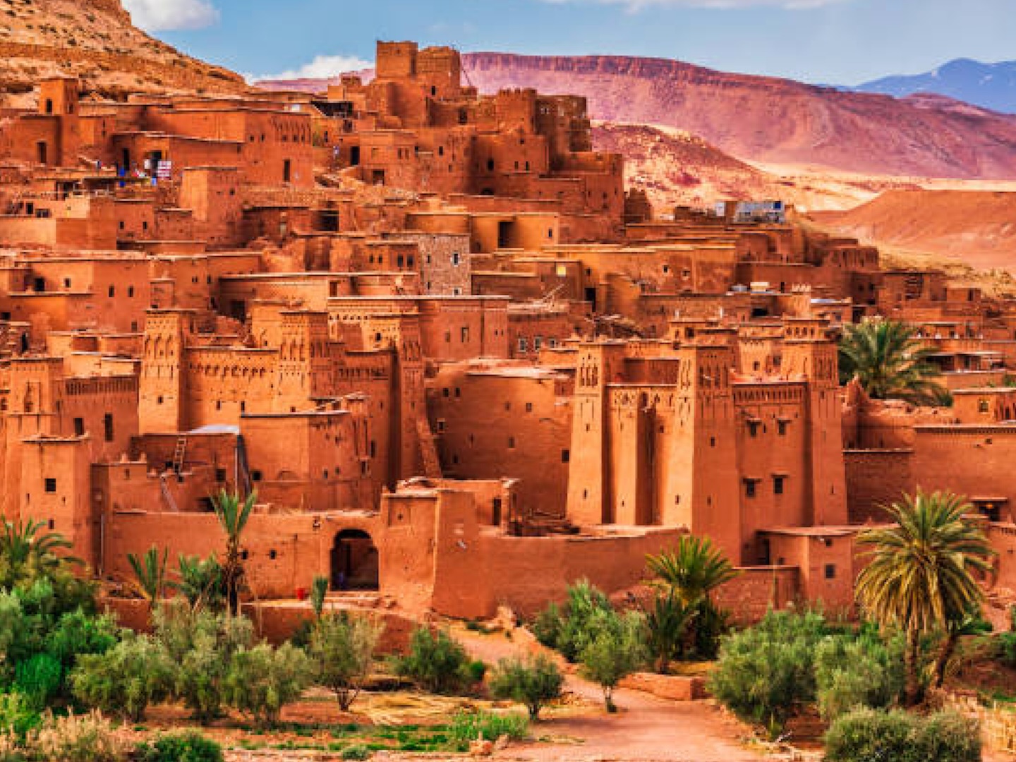 Πανοραμική άποψη του Aït Ben Haddou στο νότιο Μαρόκο, με τις χαρακτηριστικές πλινθόκτιστες kasbahs και το ορεινό τοπίο του Άτλαντα. Σταθμός του ταξιδιού Μαρόκο – Άτλαντας 4.167 m & Σαχάρα, του Basecamp Travel, τον Ιούνιο του 2027. Aït Ben Haddou στο Μαρόκο, το ιστορικό οχυρωμένο χωριό στους πρόποδες του Άτλαντα